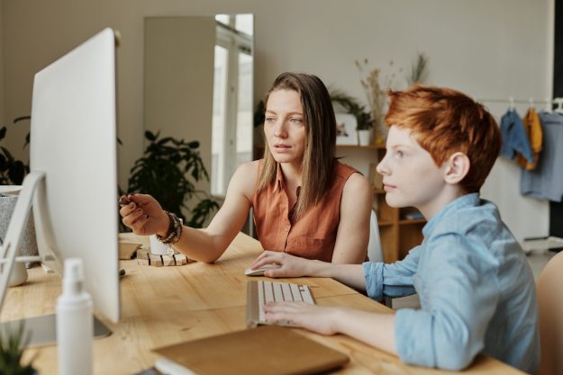 future of education, woman teaching a child on a PC