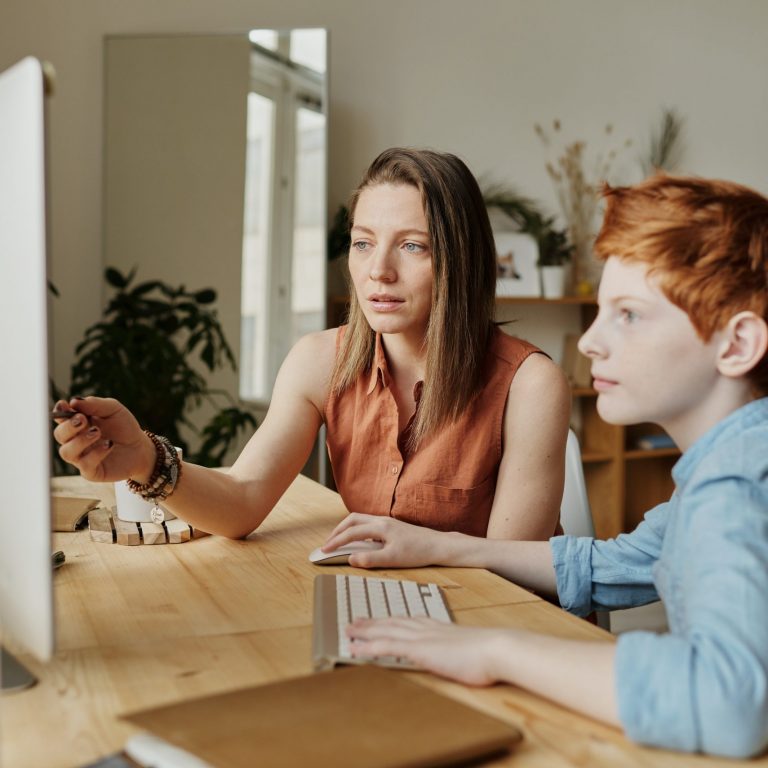 future of education, woman teaching a child on a PC