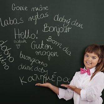 Schoolgirl presenting foreign phrases on blackboard